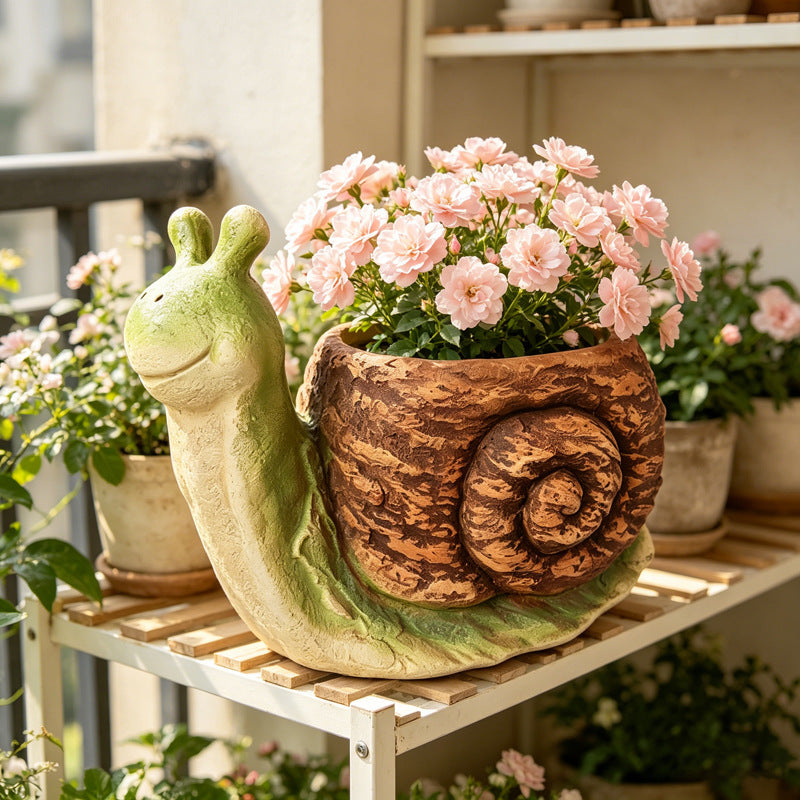 The Slow Gardener Planter — a snail garden planter with a shell planted with pink flowers