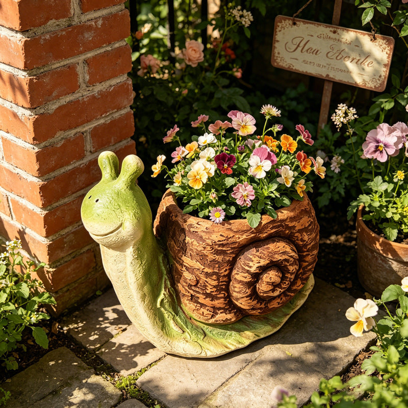 The Slow Gardener Planter beside a brick wall in a flowering cottage garden